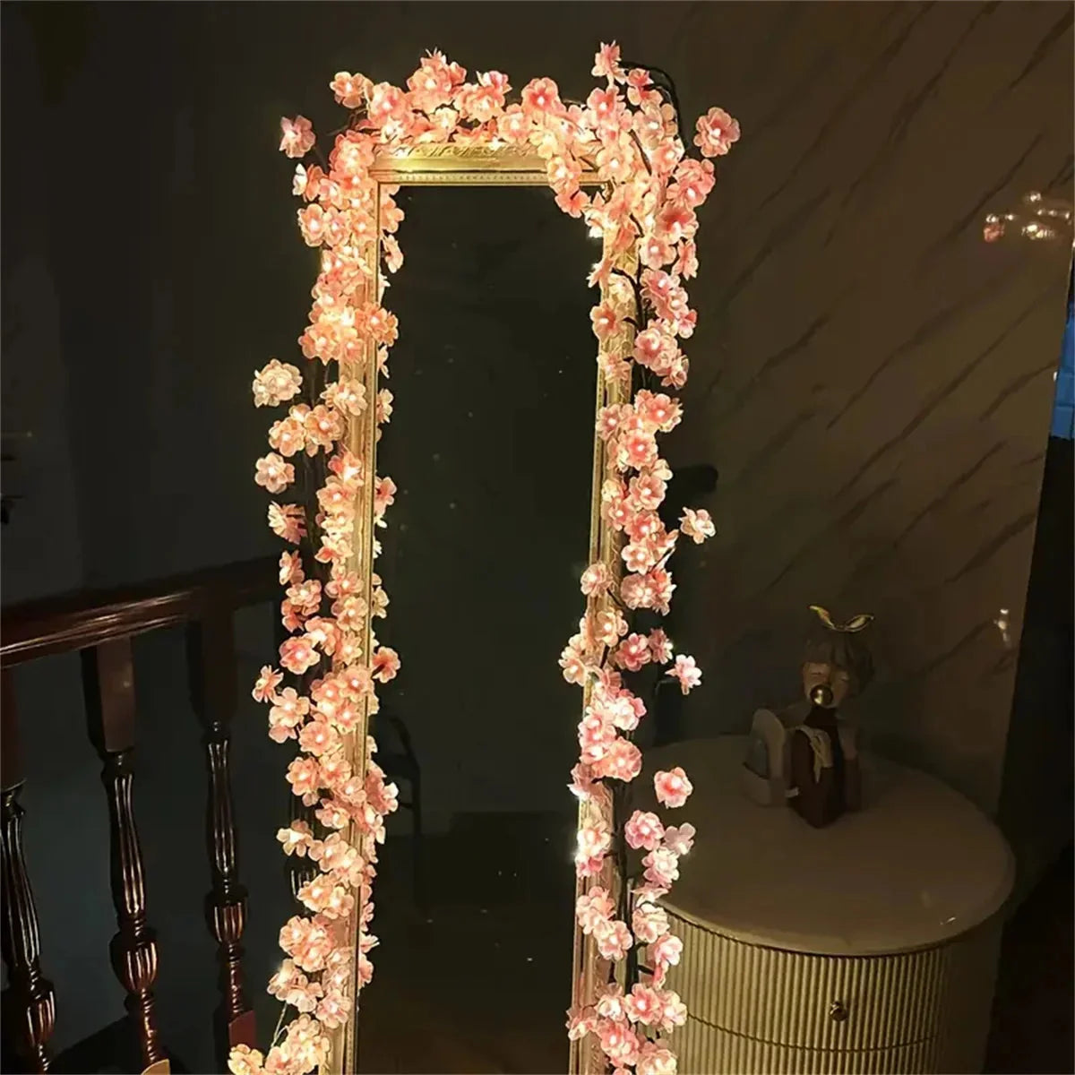 Cherry blossom LED lights wrapped around tall mirror frame, warm white pink blossoms