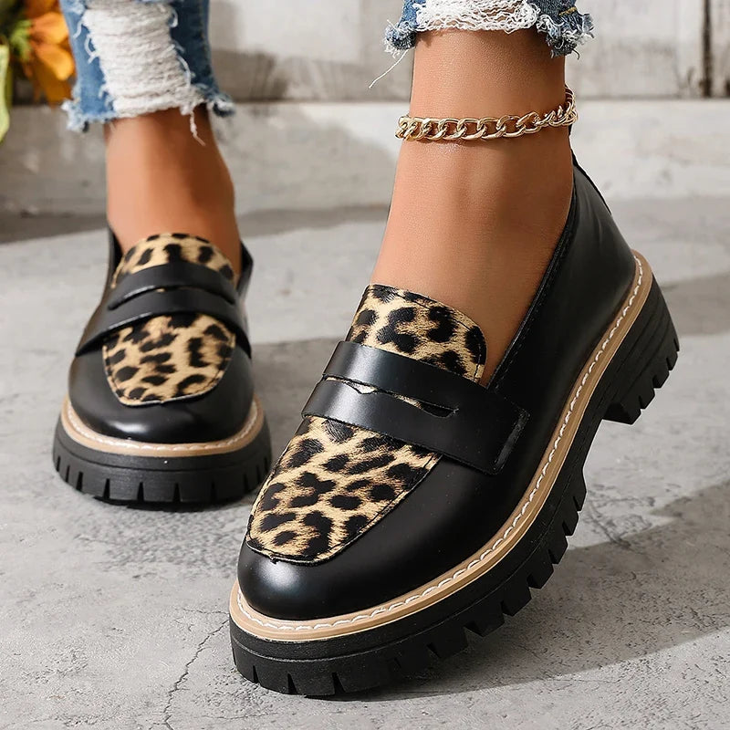 Black slip-on platform loafers with leopard print panels and buckle straps.