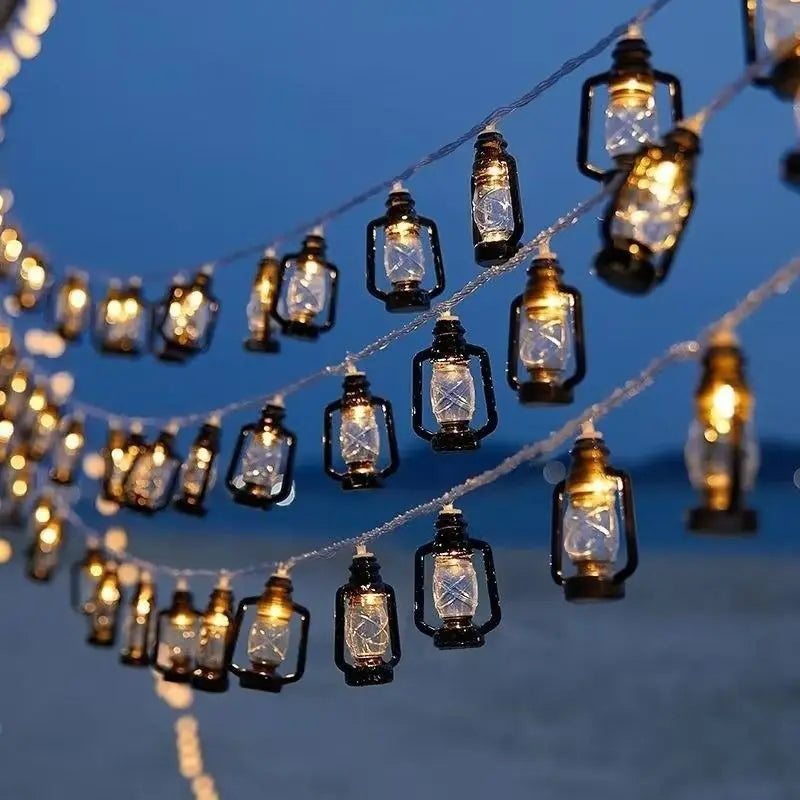Solar lantern string lights with multiple bottle-shaped glass lamps across blue dusk sky