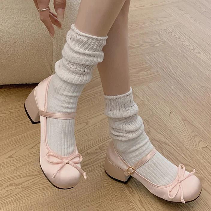 Pink Mary Jane ballet flats with ankle strap and bow, worn with white ribbed socks