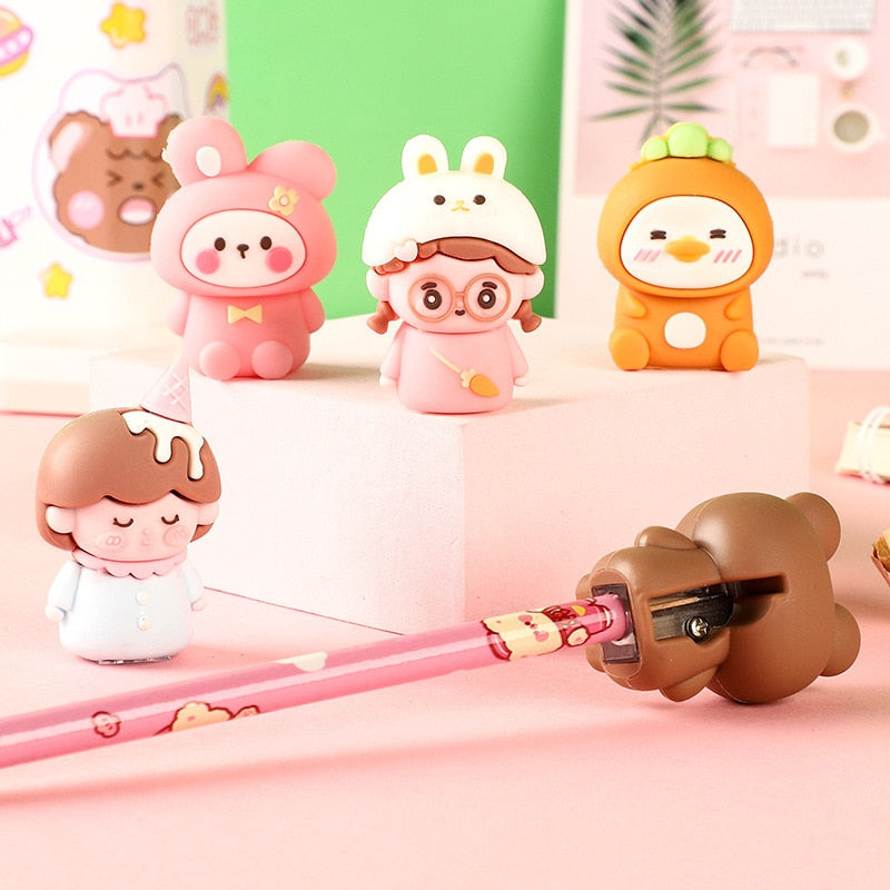 Group of cute animal pencil sharpeners standing on a block, with a pink pencil.