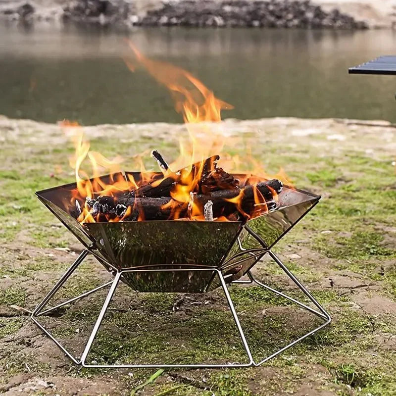 Portable folding wood stove brazier with burning coals and flames on metal stand