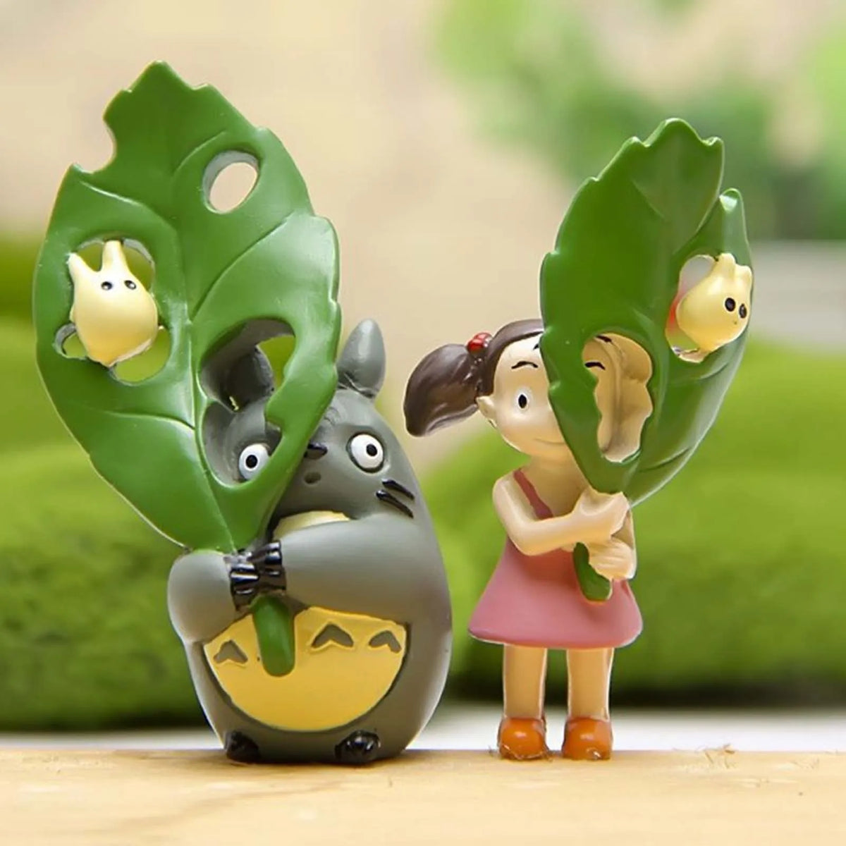 Cute leaf animal figurine: girl in pink dress inside green leaf with small critters