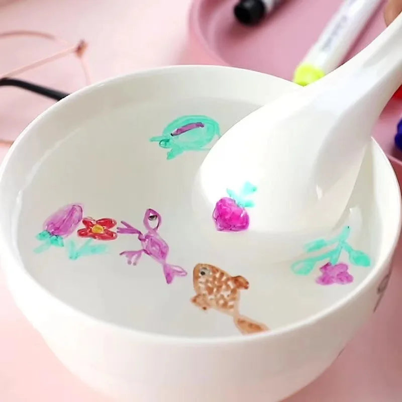 White ceramic spoon with floating colorful animal designs created by ink markers
