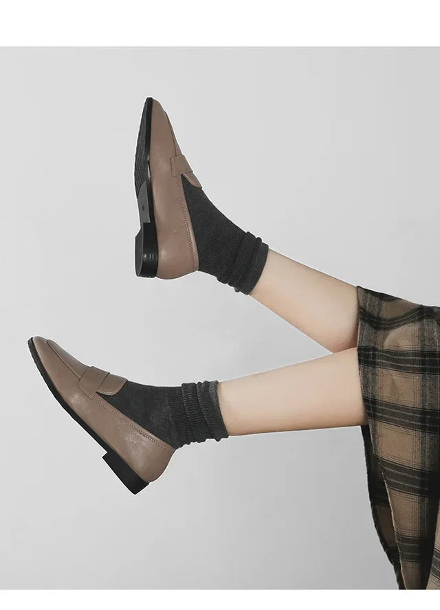 Women’s taupe leather slip-on loafers, round toe, low flat sole.