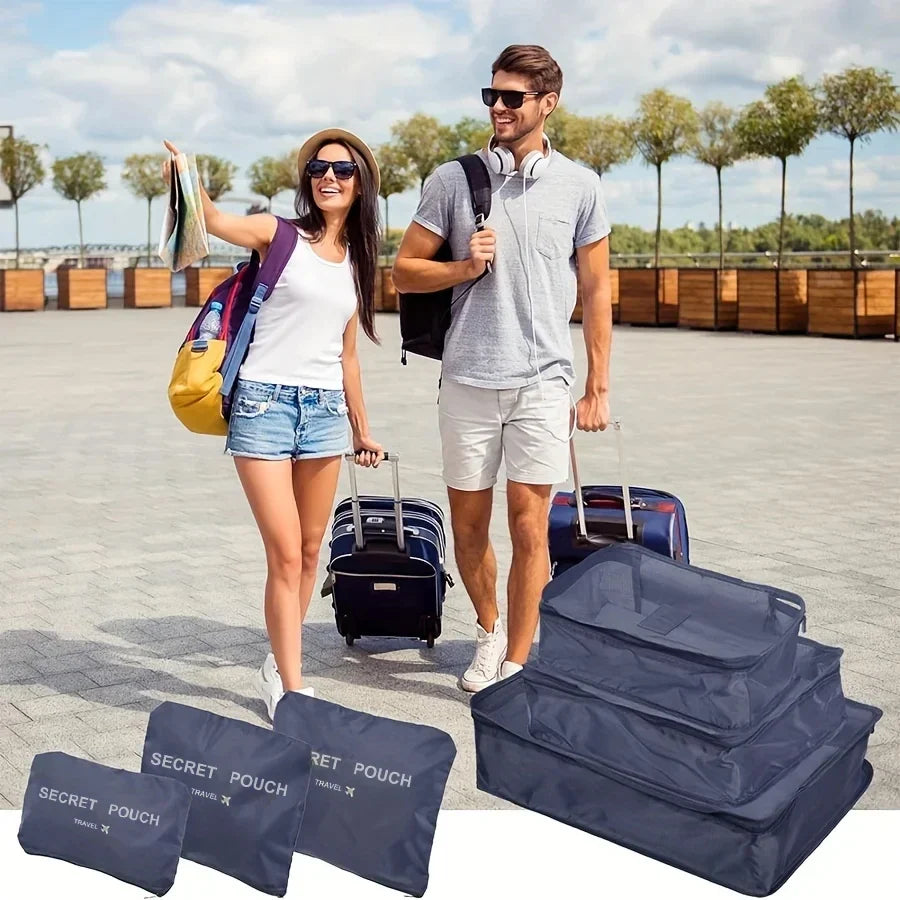 Waterproof packing cube set with 6 navy travel pouches laid out with luggage