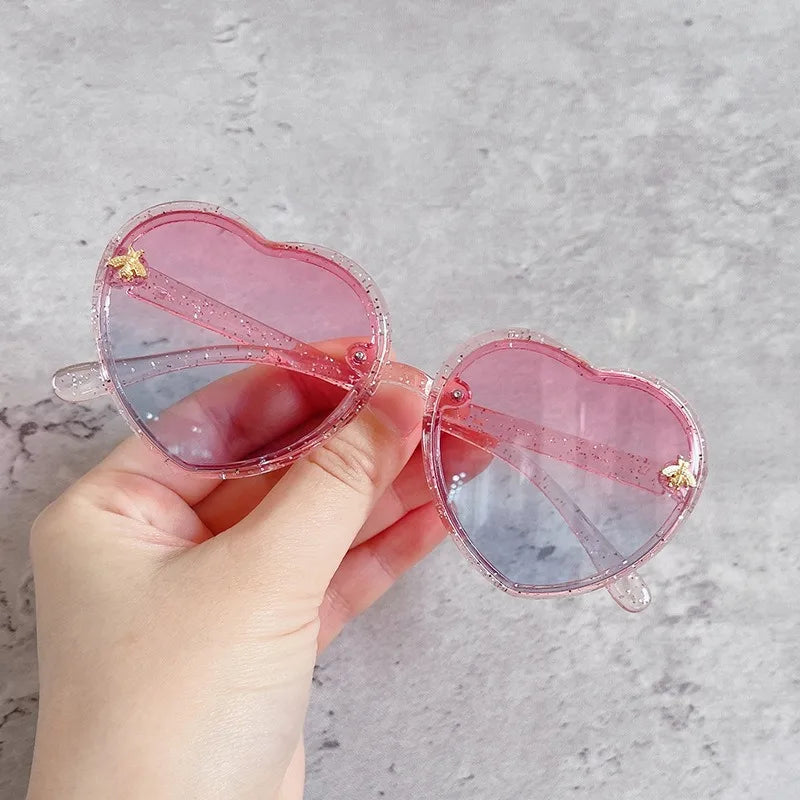 Kids heart-shaped sunglasses with pink transparent frames and pink tint lenses