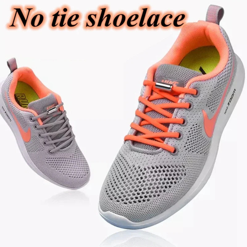 No-tie elastic shoelaces on gray sneakers with orange lace cords and silver metal caps