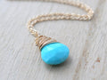 Turquoise teardrop solitaire pendant necklace with wire-wrapped cap and gold-tone chain