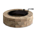 Round concrete block fire pit with black cooking grill grate and fire poker