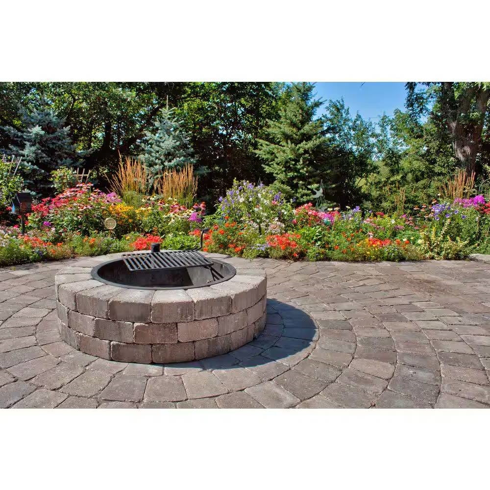 Outdoor round fire pit kit in stacked concrete blocks with grill grate