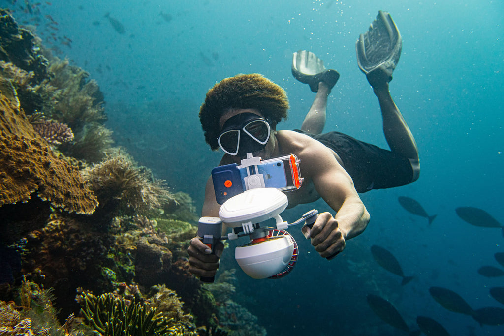 Diver wearing a clear waterproof phone case with orange accents and front window.