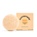 Moisturizing shampoo bar in peach with boxed Mighty Mango label behind it