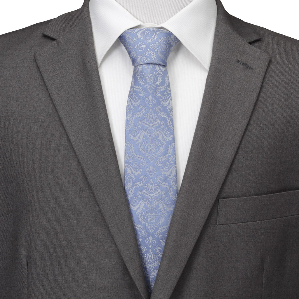 Blue damask necktie worn with a white dress shirt and gray suit jacket.