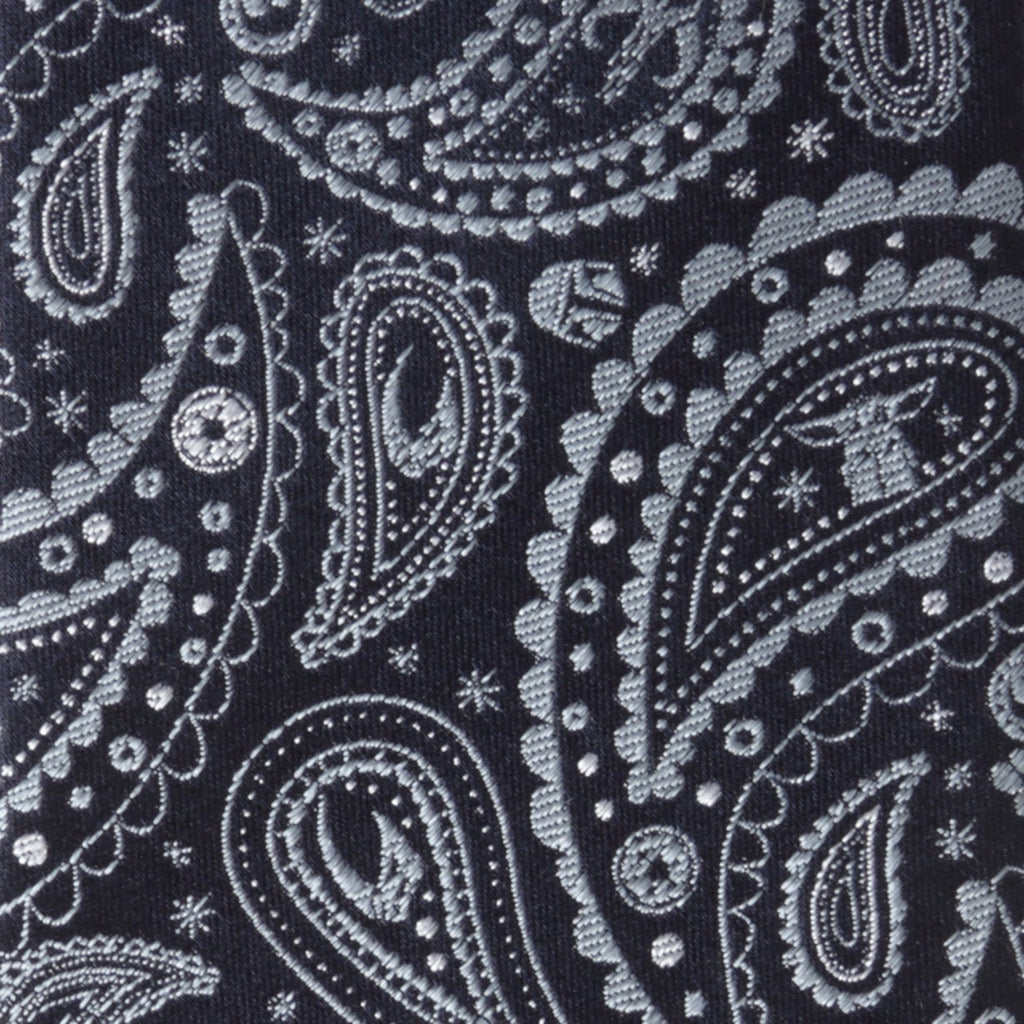Dark navy paisley tie fabric close-up with white swirls, dots, and teardrop motifs