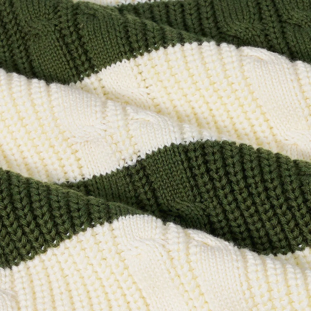 Close-up of striped cable knit fabric in cream and dark green bands