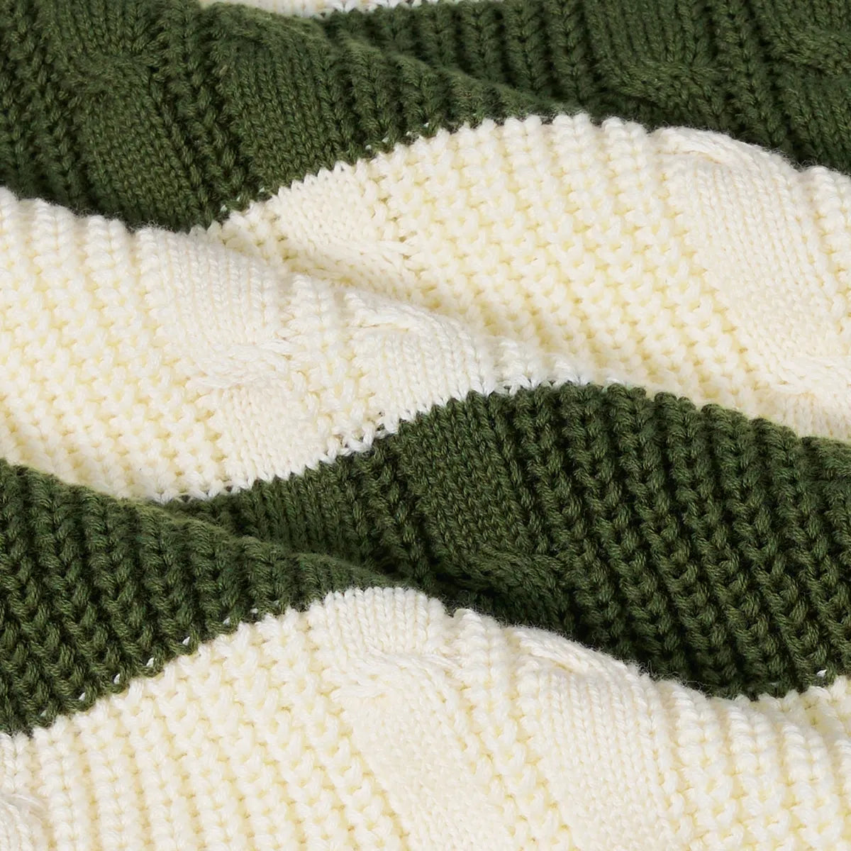 Close-up of striped cable knit fabric in cream and dark green bands