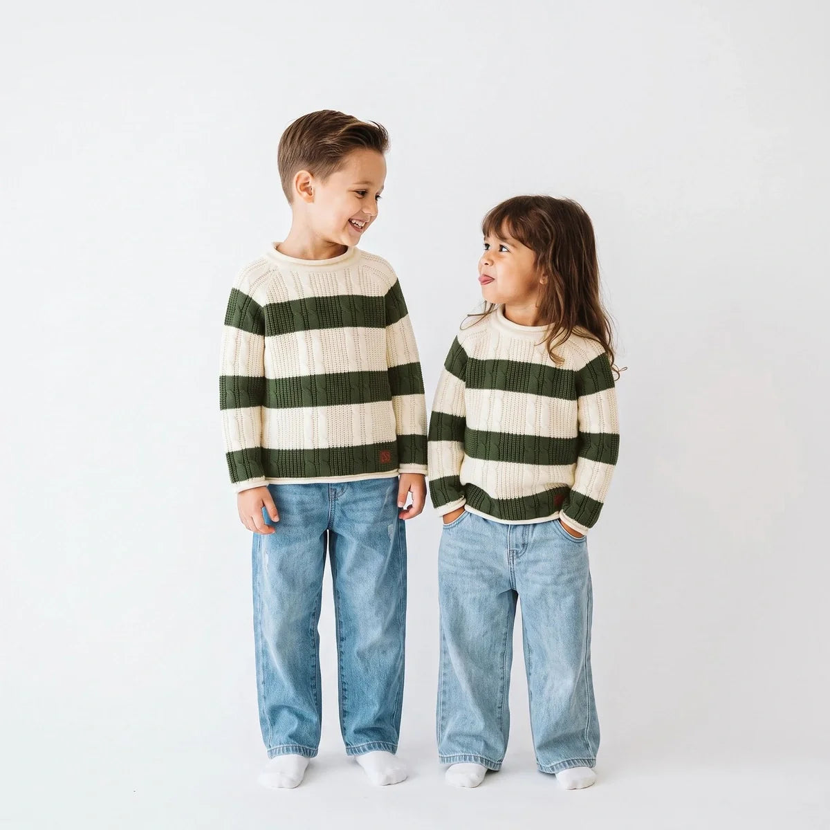 Children's striped cable knit roll neck sweater, cream and dark green, on two kids