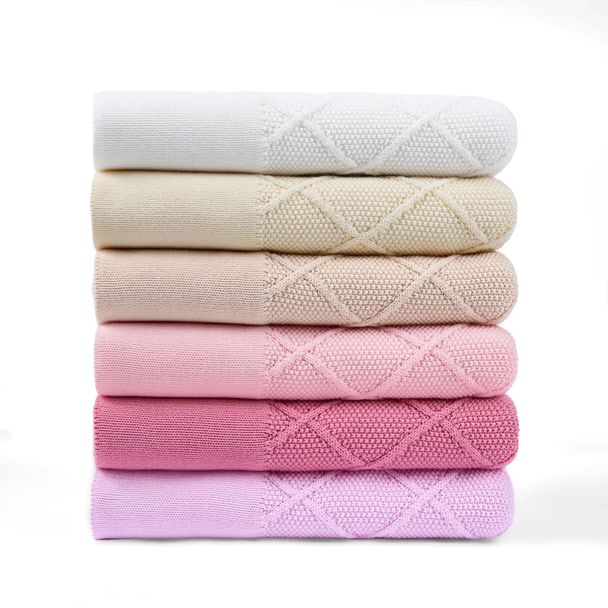 Stack of folded baby knit blankets in pink and neutral tones with diamond pattern