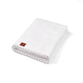 Pointelle baby knit blanket in white, folded with textured eyelet pattern and corner tag.