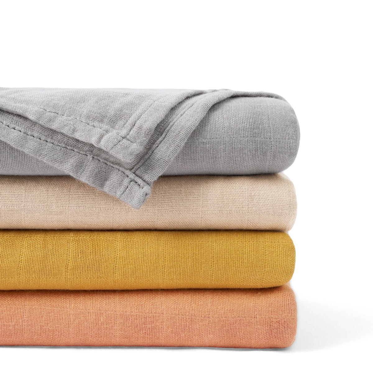 Stacked muslin swaddle blankets in multiple colors with folded fabric corners