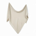 Cream baby muslin swaddle blanket with draped triangular shape and stitched edges