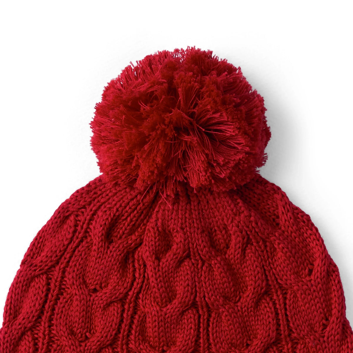 Red cable knit pom beanie close-up showing chunky knit texture and pom top