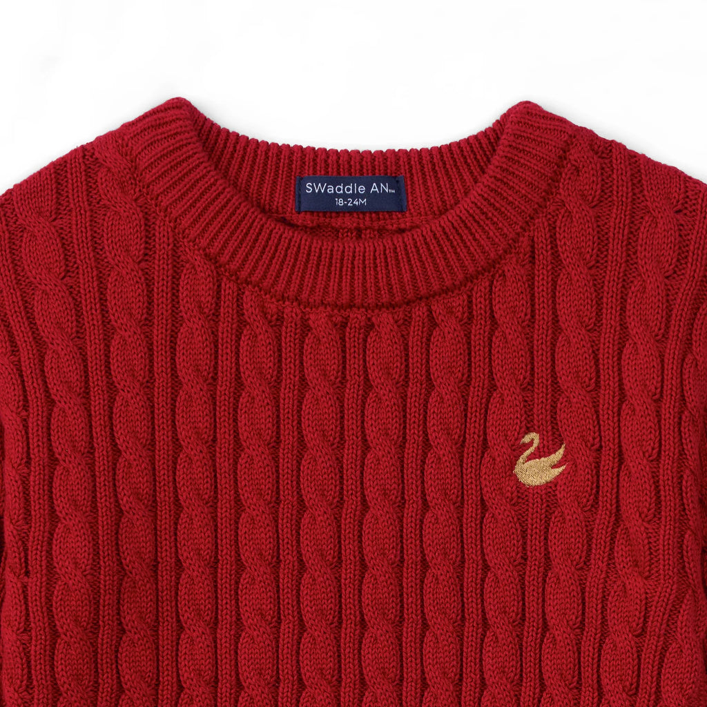 Red knit baby sweater close-up with ribbed collar and small chest logo