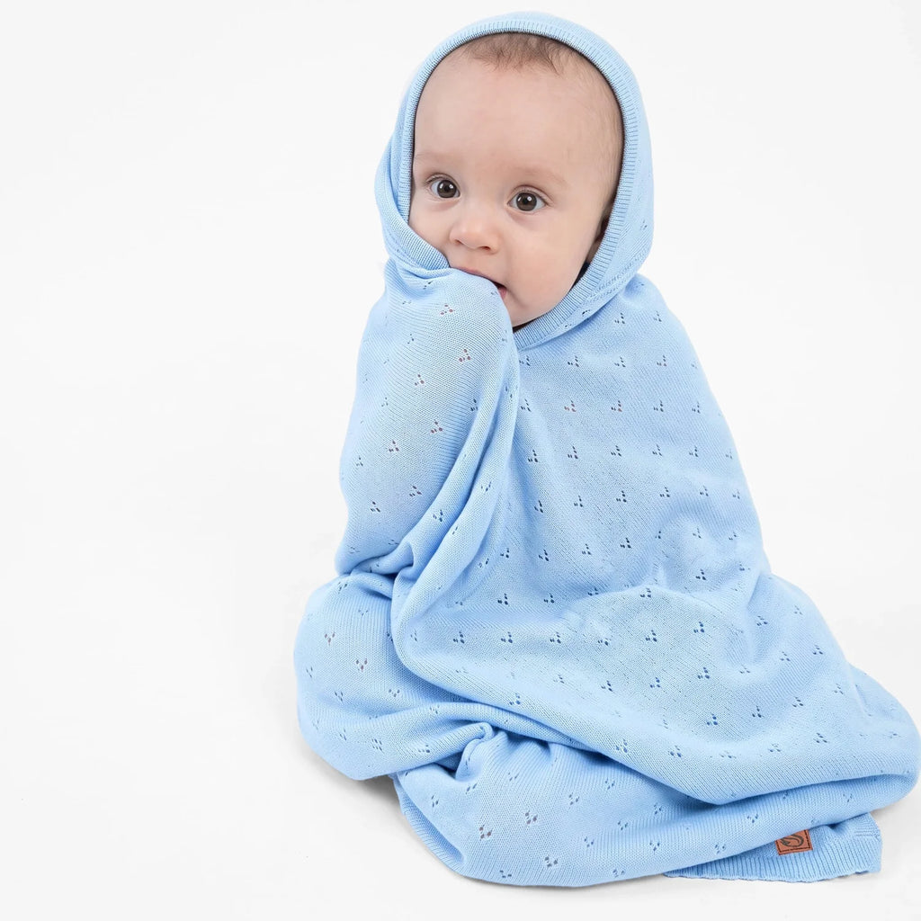 Baby blue pointelle knit baby blanket draped over a baby in a hooded wrap