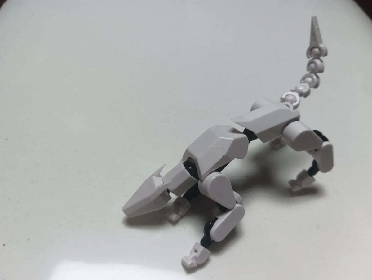 Gray multi-jointed robot action figure lying pose with sword-like accessory