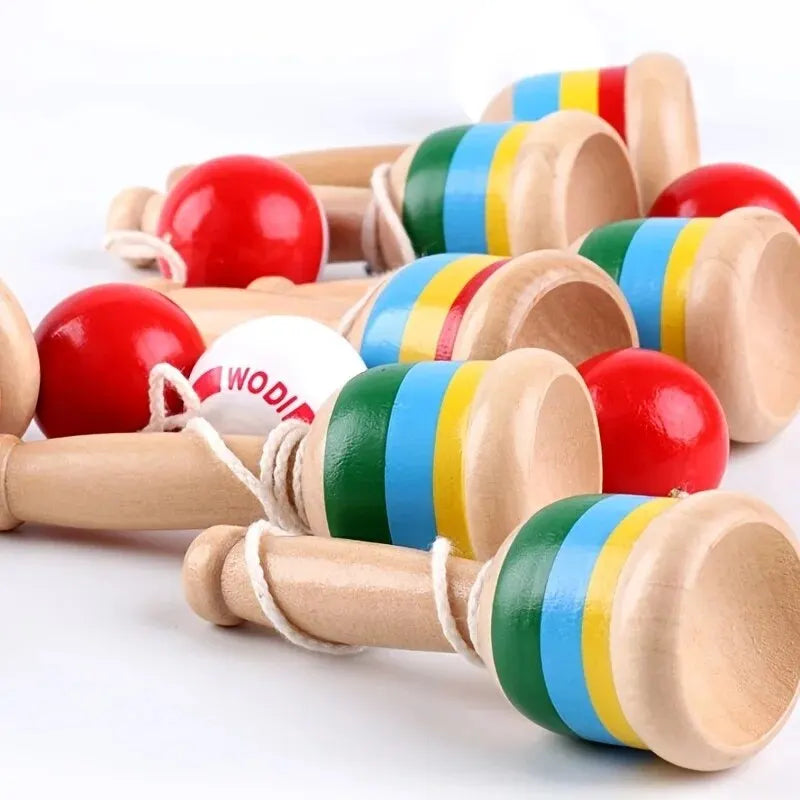 Close-up of wooden cup-and-ball toy cups with red balls on strings