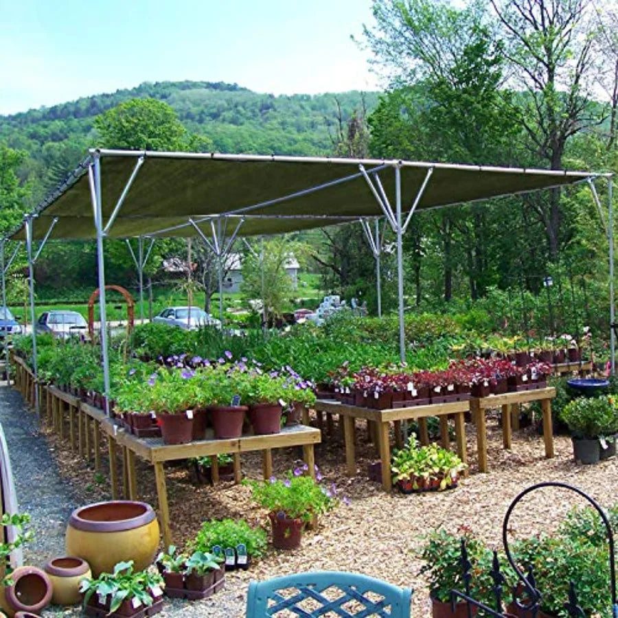 Green tarpaulin cover stretched over raised garden tables outdoors