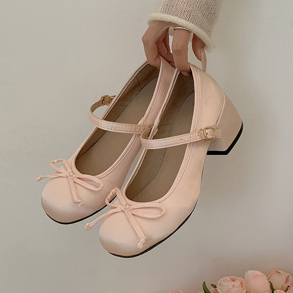 Blush pink Mary Jane ballet flats with ankle strap, bow, and low heel