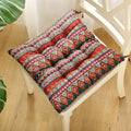 Blue-and-red patterned square seat cushion with carrying strap, on chair