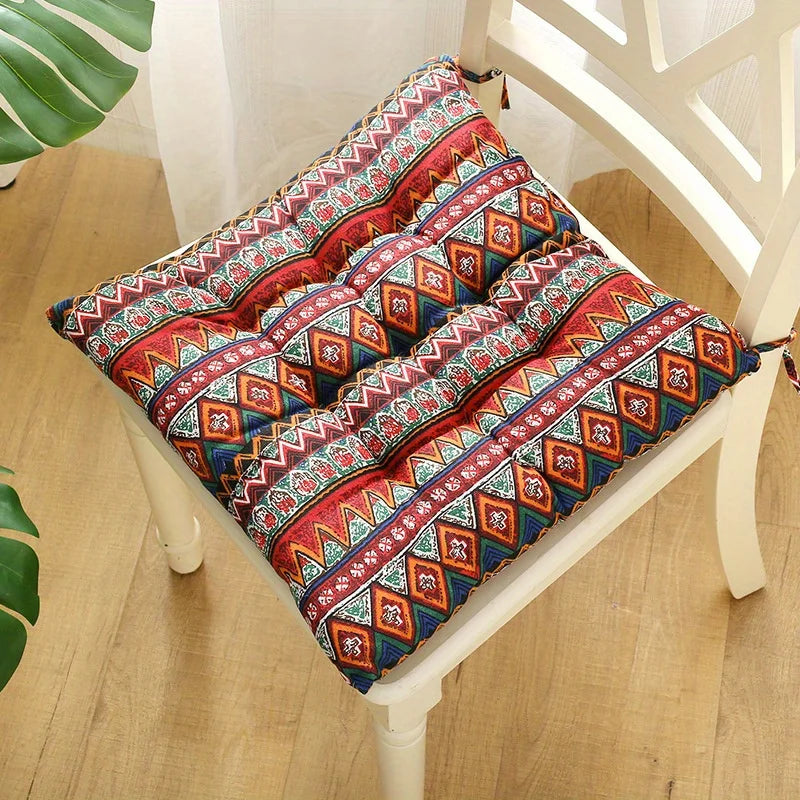 Blue-and-red patterned square seat cushion with carrying strap, on chair