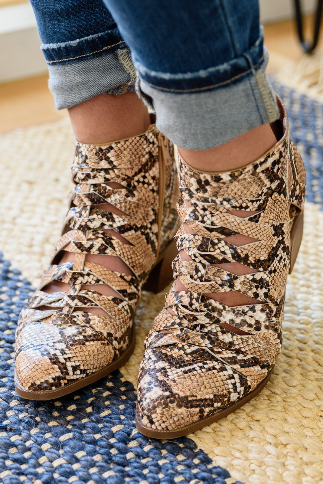 Snakeskin-print ankle boots with lace-up front and tan/brown block heel, close-up