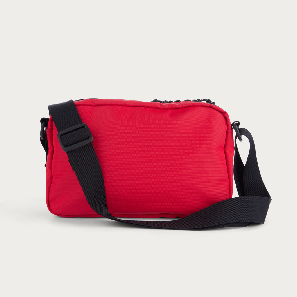 Red shoulder bag with adjustable black strap and front flap pocket