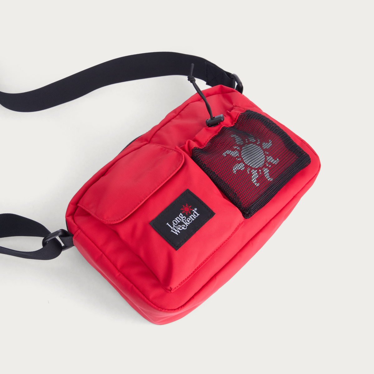Red crossbody bag with front flap, mesh pocket and Long Weekend patch