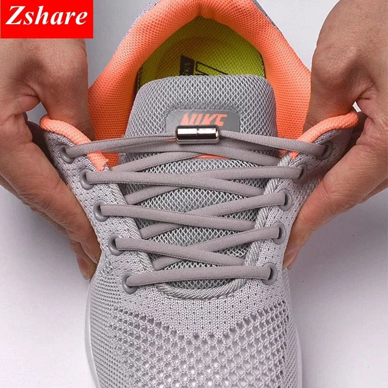 No-tie elastic shoe laces on a gray sneaker with orange elastic loops and silver caps