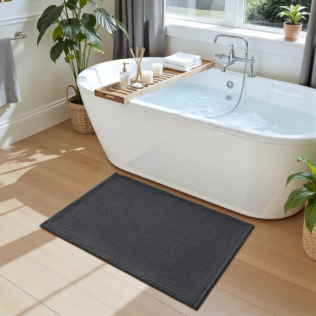 Dark grey non slip-style bath mat with textured surface near bathtub