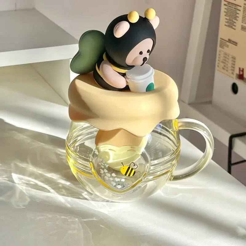 Glass tea infuser mug with bear character topper holding a honey pot infuser