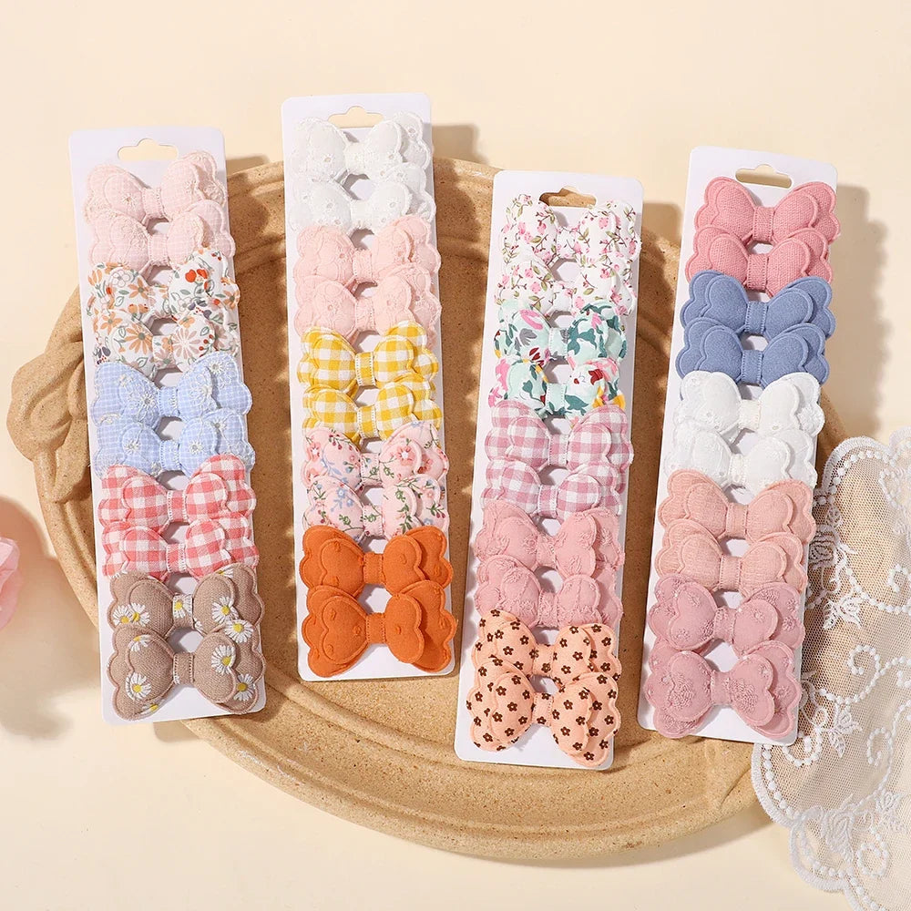 Assorted pack of baby bowknot hair clips in floral, gingham, and solid colors