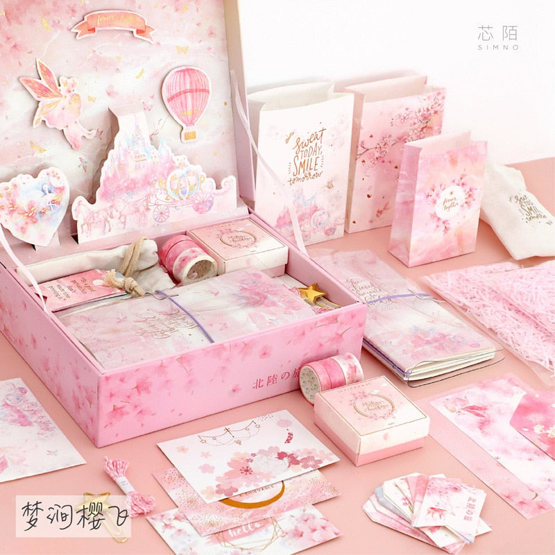 Pink stationery gift set box with illustrated cards, tapes, and gift paper items