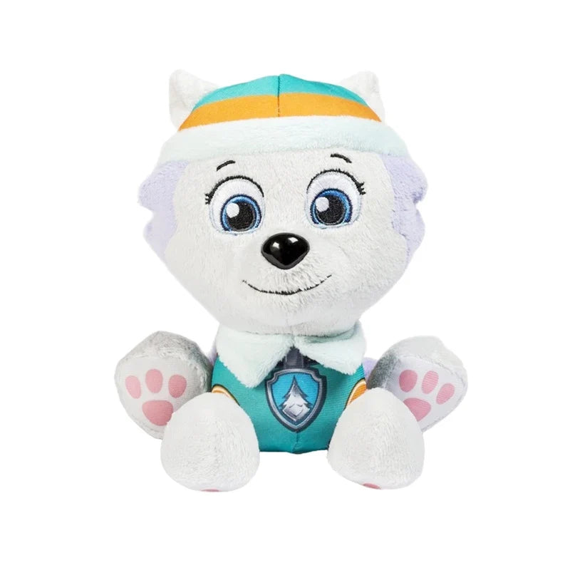 White plush puppy doll with blue eyes, light cap, and teal paw badge on chest