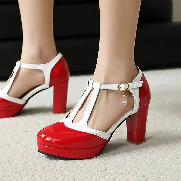 Red patent pumps with white T-strap buckle and round toe; square block heel.