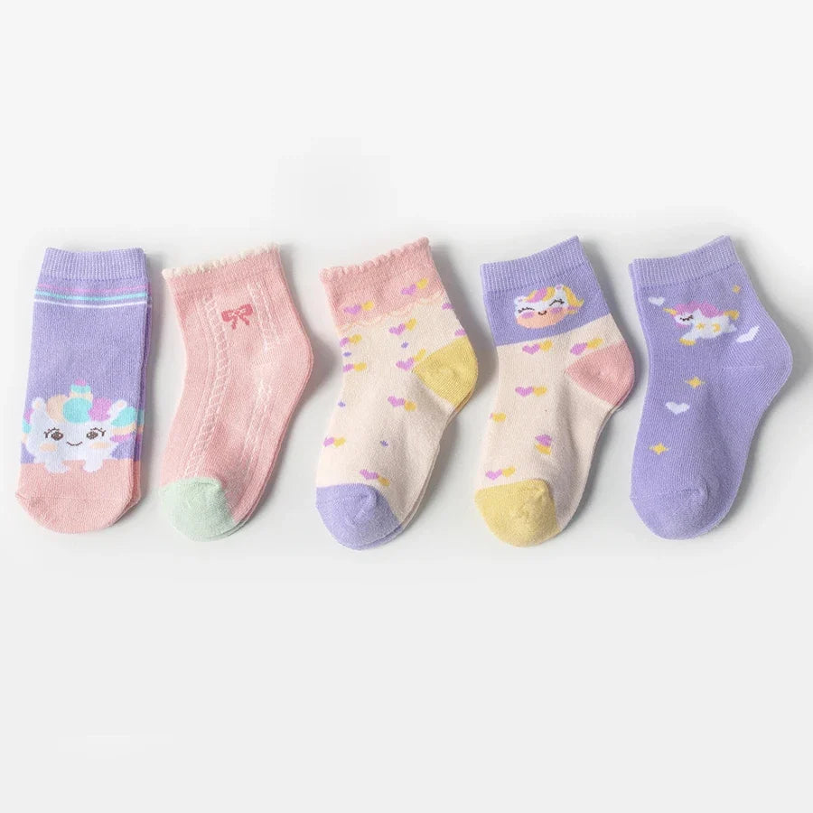 Five kids mid-calf socks lined up: lavender, blush, and cream with unicorns, stars, and bows.