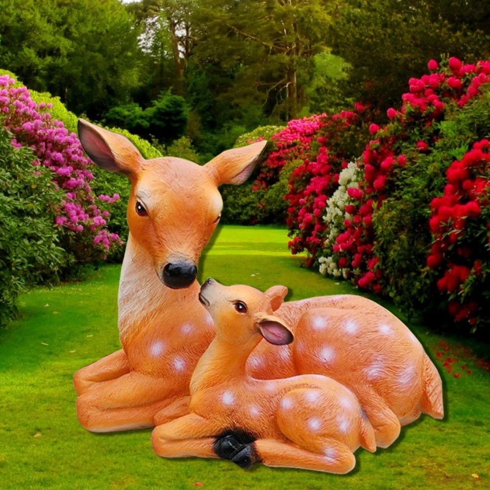 Doe and fawn deer statue set, seated mother deer with fawn lying beside her