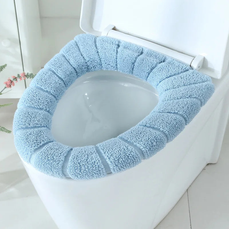 Light blue plush toilet seat cover mat fitted on a toilet seat