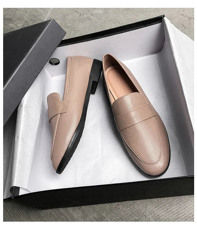 Women’s beige leather slip-on loafers, rounded toe, low flat sole.