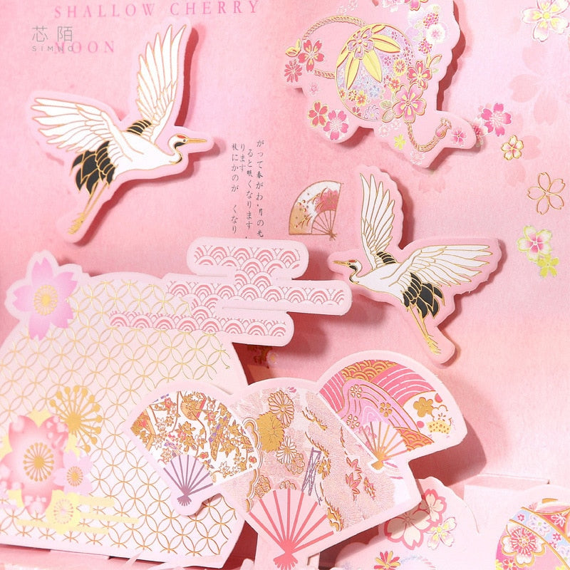 Pink decorative sticker sheets with birds, flowers, and fan motifs on cardstock
